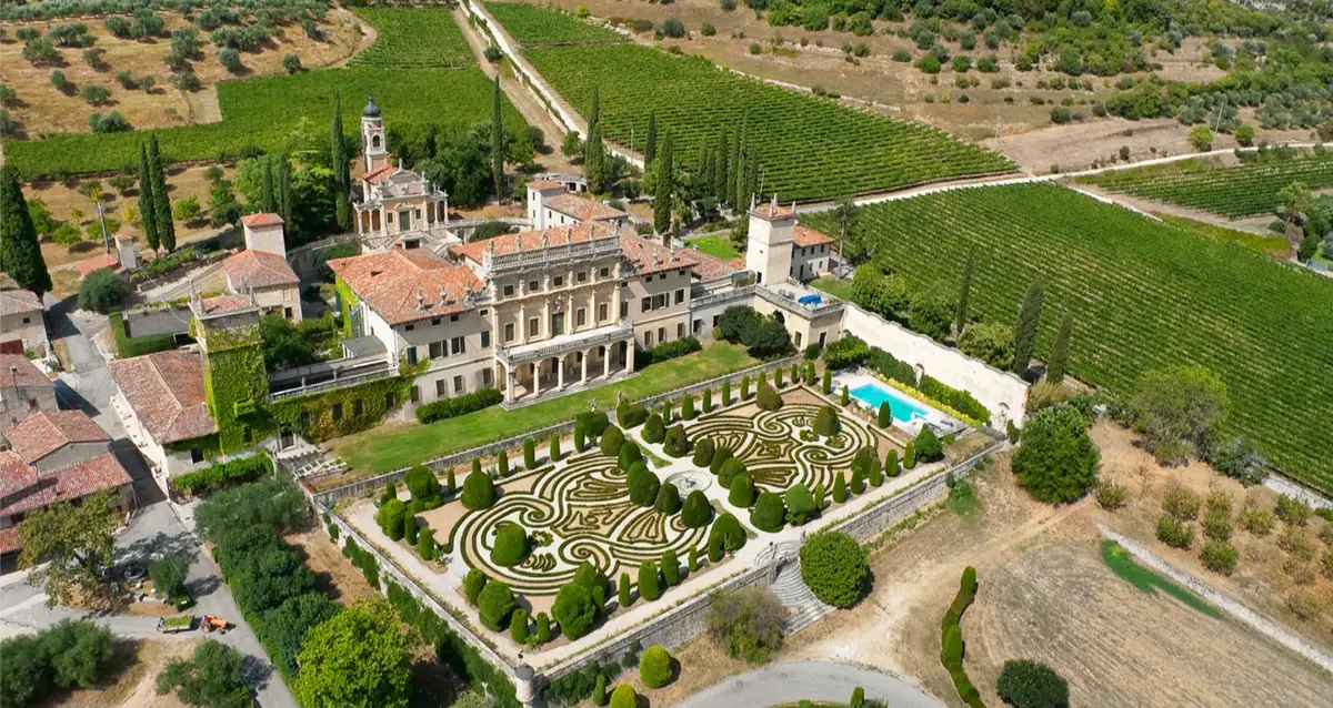 A Venetian villa with formal box parterre gardens and a pool, set among the vineyards of the Valpolicella hills near Verona